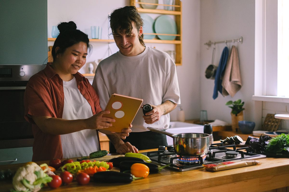 Un couple prépare un repas ensemble dans sa cuisine